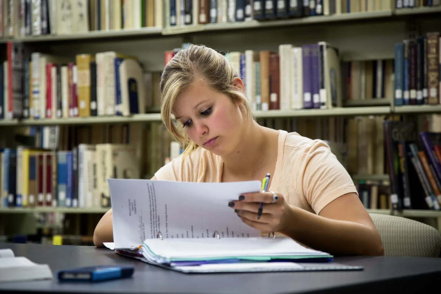 A researcher working with documents at a table in the library.