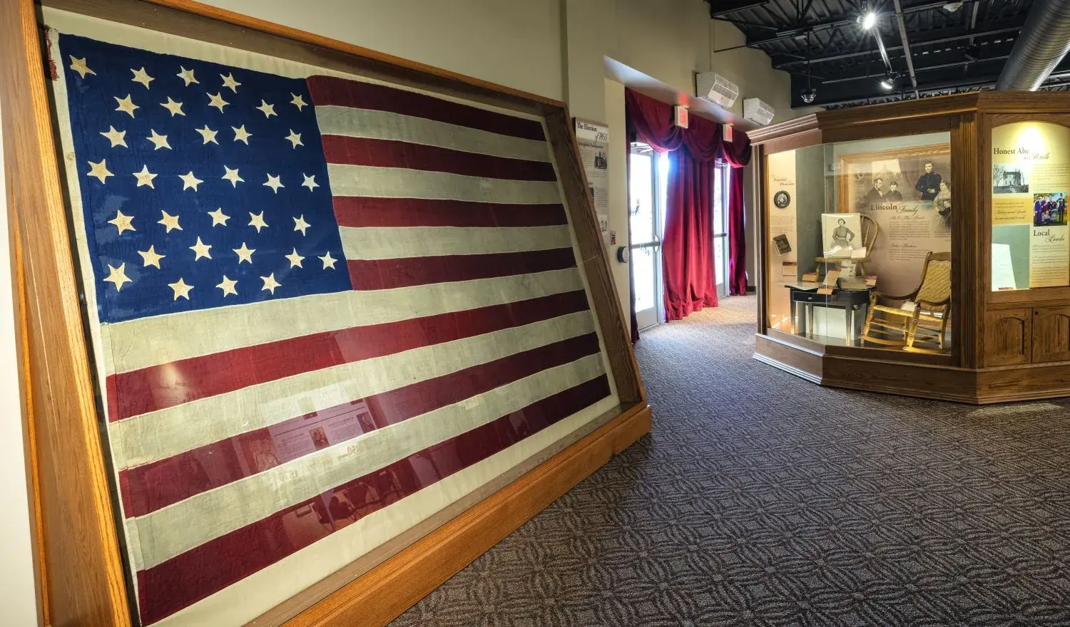 The first-floor gallery, with a large historic American flag mounted on the wall above display cases.