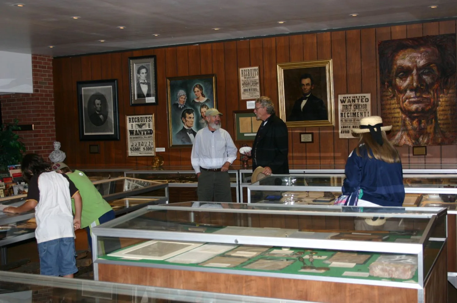 Visitors browsing display cases in the Lincoln College Museum inside the McKinstry Library.